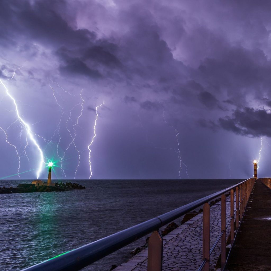 lightning bolts over dark storm clouds at night