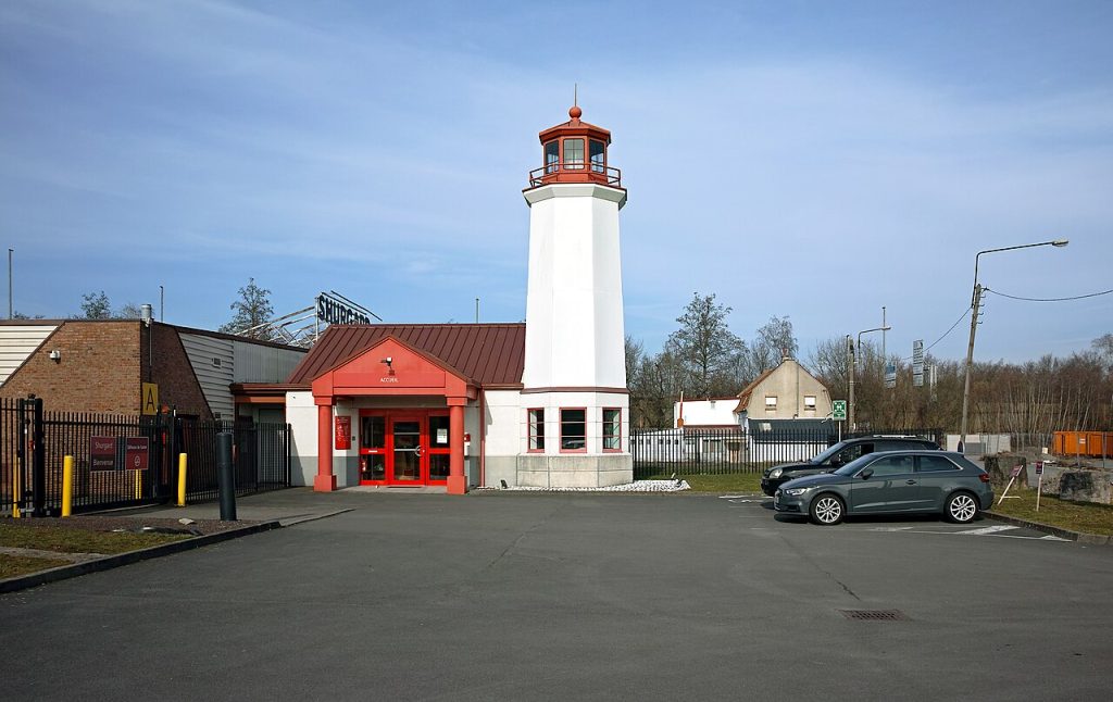 Self storage facility entrance with a lighthouse tower on a clear day